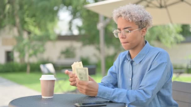 Jovem mulher africana com dólares de contagem de café no café ao ar livre — Vídeo de Stock