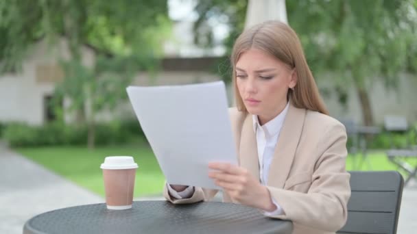Joven empresaria leyendo documentos en el café al aire libre — Vídeos de Stock