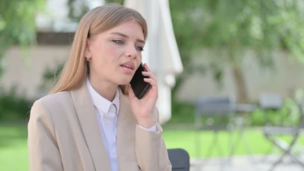Молодая предпринимательница разговаривает по телефону — стоковое видео