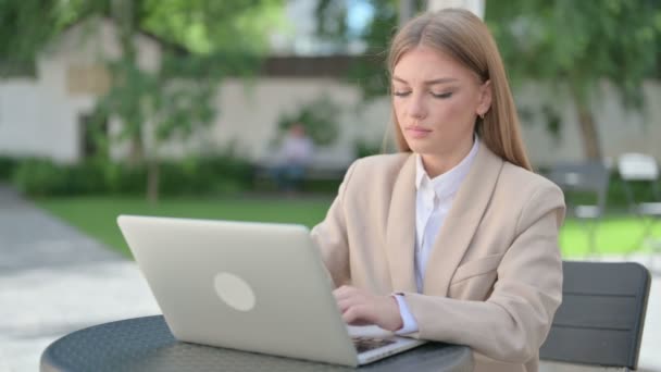 Jeune femme d'affaires avec ordinateur portable ayant la douleur au poignet dans le café extérieur — Video