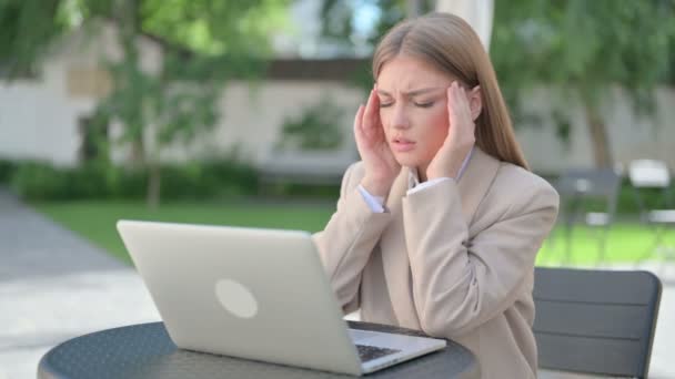Joven empresaria con portátil con dolor de cabeza en Café al aire libre — Vídeos de Stock