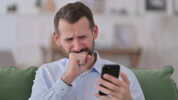 Jeune homme réagissant à la perte sur Smartphone — Photo