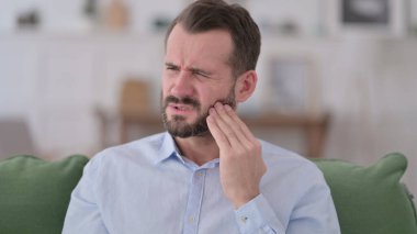 Hasta genç adamın evinde diş ağrısı var. 