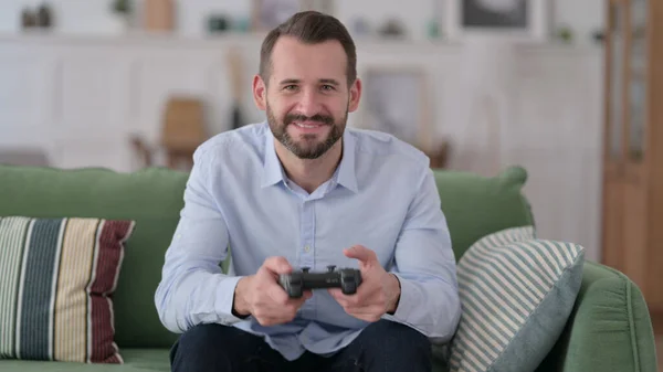 Aufgeregter junger Mann spielt Videospiel und gewinnt — Stockfoto