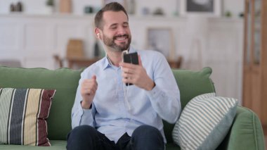 Genç Adam Evde Akıllı Telefon 'da Müzik Dinliyor