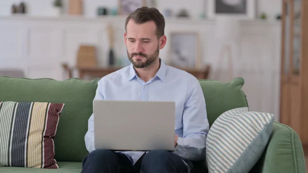 Jeune homme travaillant sur ordinateur portable sur canapé — Photo