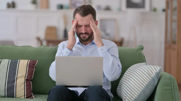 Young Man with Laptop having Headache on Sofa — Stock Photo, Image