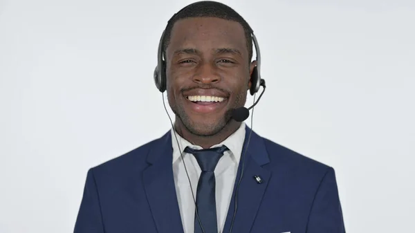 Uomo d'affari africano sorridente con auricolare per call center, sfondo bianco — Foto Stock