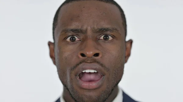 Närbild av chockad ung afrikansk man, vit bakgrund — Stockfoto
