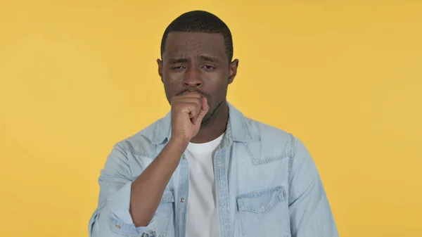 病気の若いアフリカ人男性咳,黄色の背景 — ストック写真