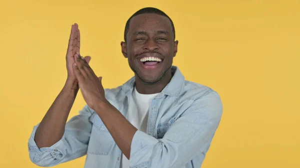 Joven africano positivo aplaudiendo, fondo amarillo —  Fotos de Stock