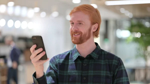 Porträt des Rotschopfmannes beim Videoanruf auf dem Smartphone — Stockfoto