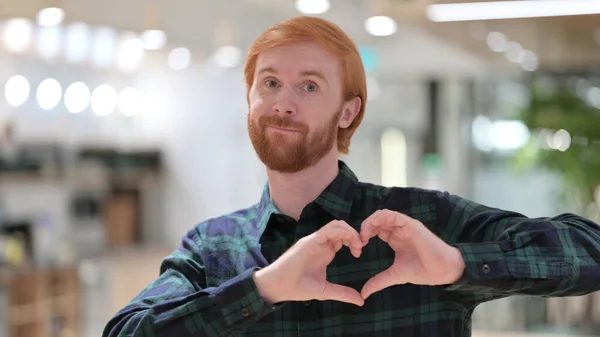 Retrato del hombre pelirrojo haciendo la señal del corazón a mano — Foto de Stock