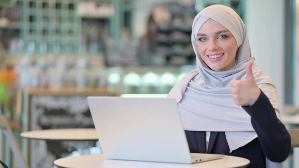 Positive Young Arab Woman with Laptop doing Thumbs up