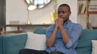 Koltukta oturan endişeli Afrikalı genç adam endişeli. 