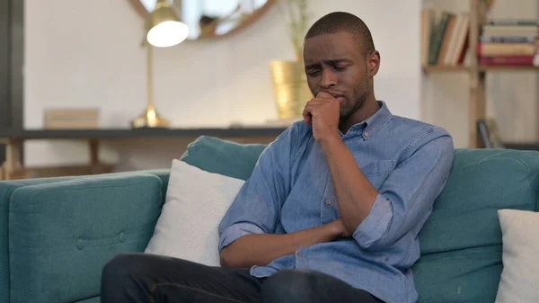 Joven africano sentado y llorando en el sofá —  Fotos de Stock