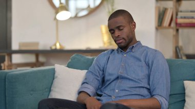 Uykucu genç Afrikalı adam şekerleme yapıyor Kanepede oturuyor 