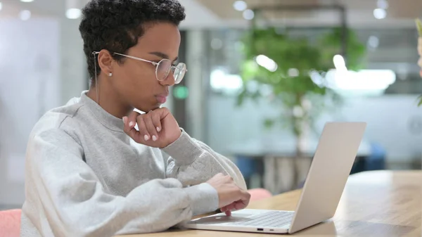 非洲青年妇女在笔记本电脑上思考和工作 — 图库照片