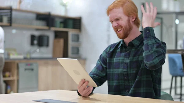 Verlies, roodharige man reageert op mislukking op tablet — Stockfoto