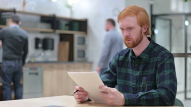 Kafe 'de Kızıl Saçlı Adam Belgeleri Okuyor 