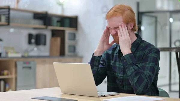 Homem ruivo com dor de cabeça usando laptop no café — Fotografia de Stock