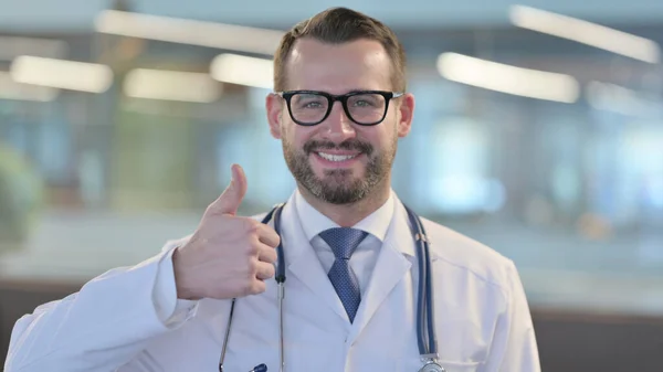 Portret młodego lekarza pokazujący kciuki w górę znak — Zdjęcie stockowe