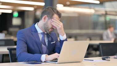 Orta yaşlı baş ağrısı olan yorgun bir iş adamı.