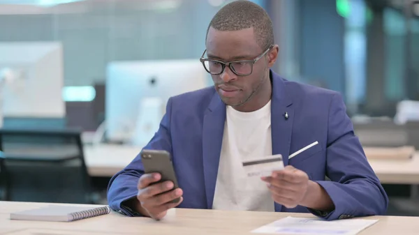 Pagamento online di successo su smartphone da parte di un giovane imprenditore africano — Foto Stock