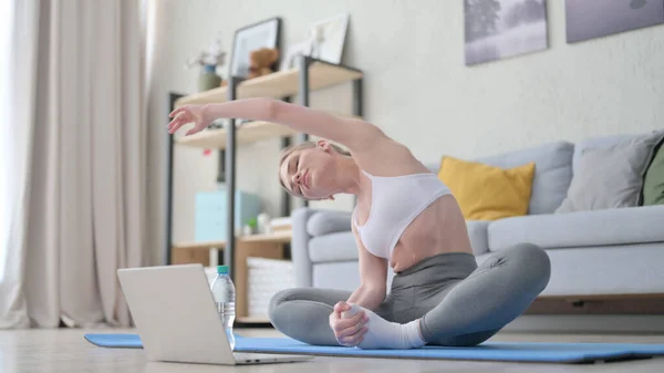 Mujer haciendo ejercicio sobre estera de yoga en casa —  Fotos de Stock
