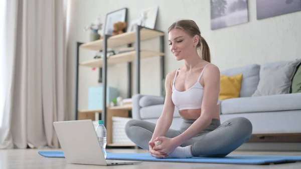 Mujer haciendo ejercicio durante el chat de vídeo en el ordenador portátil — Foto de Stock