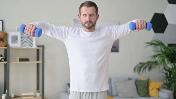 Young Man Working Out with Dumbbells at Home — Stockfoto