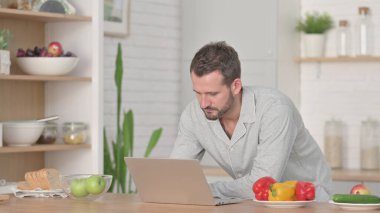 Mutfakta Dizüstü bilgisayarda çalışan adam