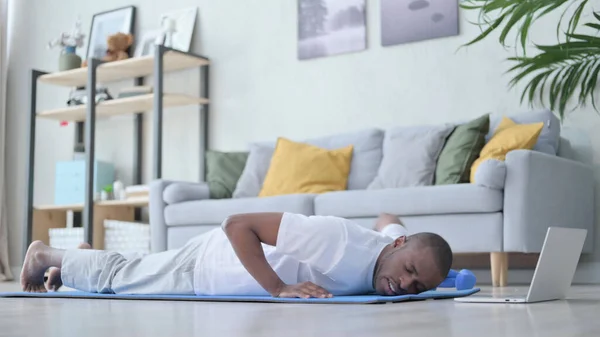 Fáradt afrikai férfi fekvőtámaszt csinál a jóga matracon otthon — Stock Fotó