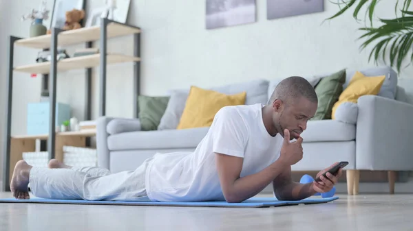 Hombre africano usando Smartphone después del ejercicio —  Fotos de Stock