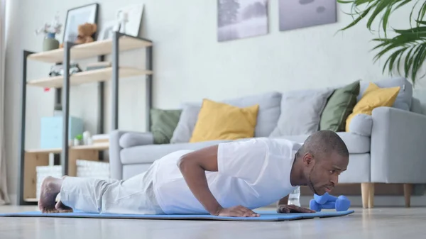 Hombre africano haciendo flexiones en la esterilla de yoga en casa —  Fotos de Stock