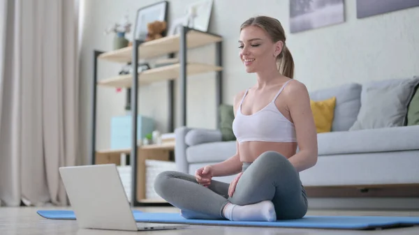 Mujer haciendo videollamada en el portátil mientras está en Yoga Mat — Foto de Stock