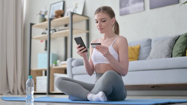 Nő Online vásárlás okostelefonon a jóga matracon — Stock Fotó