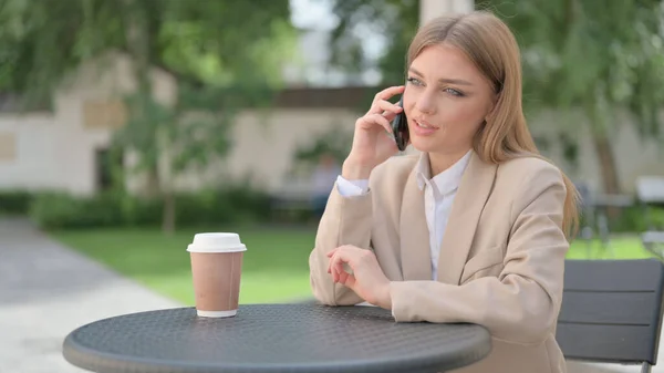 Femme d'affaires parlant au téléphone dans un café en plein air — Photo