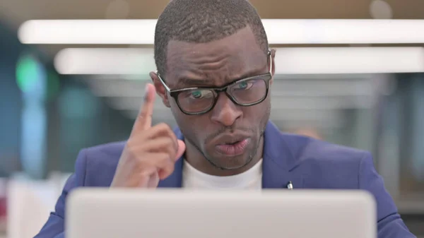 Joven empresario africano hablando en videollamada en el ordenador portátil —  Fotos de Stock