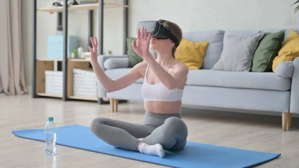 VR-készletet használó nő a jóga matracon ülve — Stock Fotó