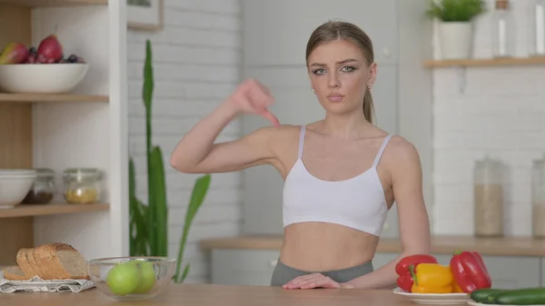 Woman Showing Thumbs Down while Standing in Kitchen — Stock Photo, Image