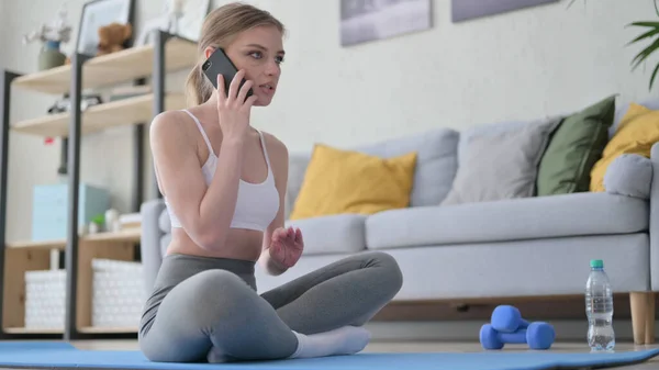 Mujer hablando por teléfono en Yoga Mat en casa —  Fotos de Stock