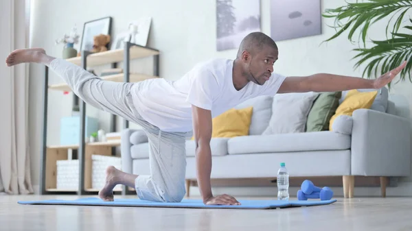 Edzés jóga matrac otthon az afrikai ember — Stock Fotó