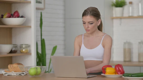 Женщина работает на ноутбуке на кухне — стоковое фото