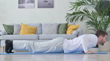 Evde şınav çeken genç adam.