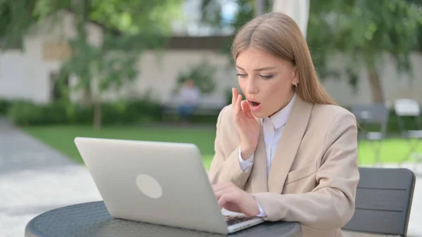 Donna d'affari sensazione di shock durante l'utilizzo del computer portatile in Outdoor Cafe — Foto Stock