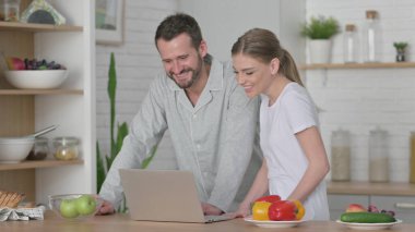 Kadın ve Adam Mutfaktaki Bilgisayarda Video Konuşması Yapıyor