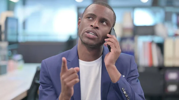 Retrato de un joven empresario africano hablando por teléfono —  Fotos de Stock