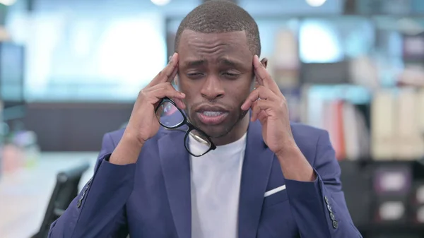 Retrato de un joven empresario africano con dolor de cabeza —  Fotos de Stock