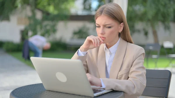 Empresária Pensando e trabalhando no laptop no café ao ar livre — Fotografia de Stock